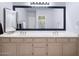 Bathroom with double vanity, updated hardware, framed mirror and modern lighting at 5513 E Grovers Ave, Scottsdale, AZ 85254