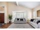 Bright living room with vaulted ceiling, striking front door, and modern furniture at 5513 E Grovers Ave, Scottsdale, AZ 85254