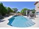 Sparkling pool features a rock waterfall, lush landscaping and a covered patio with a hot tub at 5513 E Grovers Ave, Scottsdale, AZ 85254