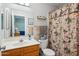 Bathroom with vanity, toilet, mirror, shelves and floral shower curtain at 5808 E Brown Rd # 140, Mesa, AZ 85205
