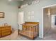 Bedroom area with crib, dresser, and soft green wall paint at 5808 E Brown Rd # 140, Mesa, AZ 85205