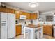 Well-lit kitchen with white appliances, wooden cabinets, and a kitchen island at 5808 E Brown Rd # 140, Mesa, AZ 85205