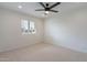Bright, carpeted bedroom with a ceiling fan and large window offering ample sunlight at 711 N 22Nd St, Mesa, AZ 85213