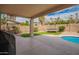 Covered patio overlooking a spacious backyard with a sparkling pool, trampoline and mature landscaping at 7170 W Crystal Rd, Glendale, AZ 85308