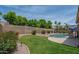 Spacious backyard featuring lush green lawn, mature trees, privacy fence and refreshing pool at 7170 W Crystal Rd, Glendale, AZ 85308