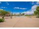 A recreational outdoor basketball court with blue and white surface, surrounded by landscaped grounds, under a sunny, blue sky at 7170 W Crystal Rd, Glendale, AZ 85308