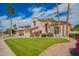 Charming two-story home featuring a lush green lawn, mature trees, and a tiled roof at 7170 W Crystal Rd, Glendale, AZ 85308