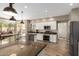 Bright kitchen boasts white cabinets, stainless steel appliances, granite counters, and a large island at 7170 W Crystal Rd, Glendale, AZ 85308
