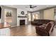 Cozy living room featuring a white brick fireplace, wood floors, and a comfortable brown reclining sofa at 7170 W Crystal Rd, Glendale, AZ 85308