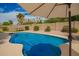 Sparkling swimming pool in a private backyard oasis, complete with a pool cleaner, patio umbrella, and drought-tolerant landscape at 7170 W Crystal Rd, Glendale, AZ 85308