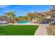 Inviting backyard with a sparkling pool, soothing waterfall feature, and comfortable covered patio seating area at 740 N Bradley Dr, Chandler, AZ 85226