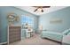 Bedroom featuring a ceiling fan, window, neutral carpet, and study desk at 740 N Bradley Dr, Chandler, AZ 85226