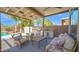 Relaxing covered patio featuring comfortable seating, an outdoor kitchen, and scenic views of the backyard pool at 740 N Bradley Dr, Chandler, AZ 85226