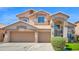 Charming two-story home featuring a three-car garage and well-manicured front yard, set against a bright blue sky at 740 N Bradley Dr, Chandler, AZ 85226