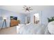 Relaxing main bedroom featuring a ceiling fan, sitting area, walk-in entry to main bath, and a light blue color scheme at 740 N Bradley Dr, Chandler, AZ 85226