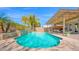 A sparkling pool with a stone waterfall feature, surrounded by lush landscaping and a shaded patio area at 740 N Bradley Dr, Chandler, AZ 85226