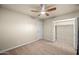 Cozy bedroom featuring a ceiling fan, plush carpet, and a closet for ample storage at 7605 N 45Th Dr, Glendale, AZ 85301