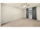 Bright bedroom features plush carpeting, ceiling fan, and a large window allowing abundant natural light at 7605 N 45Th Dr, Glendale, AZ 85301