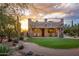 Backyard boasts a stone patio, lush turf, privacy fence, and desert landscape at 7788 E Morning Vista Ln, Scottsdale, AZ 85266