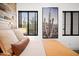Comfortable bedroom with rustic wood accent wall and views to desert landscape through window at 7788 E Morning Vista Ln, Scottsdale, AZ 85266