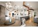Elegant dining area with chandelier, seamlessly connected to the modern, white kitchen at 7788 E Morning Vista Ln, Scottsdale, AZ 85266