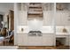 Custom kitchen with a wood-paneled range hood, modern appliances, and ample counter space at 7788 E Morning Vista Ln, Scottsdale, AZ 85266