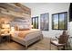 Inviting bedroom with rustic wood accent wall, two chairs, and warm lighting at 7788 E Morning Vista Ln, Scottsdale, AZ 85266