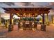 Outdoor kitchen area with bar seating under a pergola, perfect for entertaining at 7788 E Morning Vista Ln, Scottsdale, AZ 85266