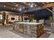 Stone kitchen bar with bar seating featuring stainless steel appliances and views of the pool at 7788 E Morning Vista Ln, Scottsdale, AZ 85266