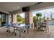Covered patio with ping pong table, TV, and outdoor seating area, perfect for entertaining at 7788 E Morning Vista Ln, Scottsdale, AZ 85266