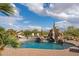 Beautiful pool featuring a rock waterfall and slide, surrounded by desert landscaping at 7788 E Morning Vista Ln, Scottsdale, AZ 85266