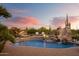 Inviting pool area featuring a rock slide, waterfall, poolside lounge chairs and desert landscape at 7788 E Morning Vista Ln, Scottsdale, AZ 85266