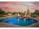 Inviting pool area featuring a rock slide, waterfall, fire pit and poolside lounge chairs at 7788 E Morning Vista Ln, Scottsdale, AZ 85266