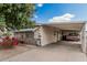 Home featuring a covered carport, a vibrant flowering bush, and desert landscaping at 8323 E Deep Canyon Ct, Mesa, AZ 85208