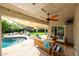 Covered patio with comfortable seating, a ceiling fan, and views of the pool, perfect for outdoor relaxation at 9015 E Altadena Ave, Scottsdale, AZ 85260