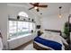 Bedroom with a large window, ceiling fan, and a bed with white bedding and a blue throw at 9015 E Altadena Ave, Scottsdale, AZ 85260