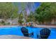 Refreshing pool with a rock waterfall feature and relaxing lounge chairs, perfect for outdoor enjoyment at 9015 E Altadena Ave, Scottsdale, AZ 85260