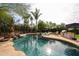 Sparkling pool surrounded by lush greenery, lounge chairs, and an outdoor kitchen, perfect for outdoor enjoyment at 9015 E Altadena Ave, Scottsdale, AZ 85260