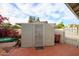 Home's backyard features storage space behind a metal gate and door at 9015 E Altadena Ave, Scottsdale, AZ 85260