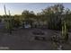 Backyard view with mature cacti, a firepit, and bench swing seating at 9690 W Martin Rd, Casa Grande, AZ 85194