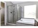Modern bathroom featuring a glass-enclosed shower, soaking tub, and natural light at 9690 W Martin Rd, Casa Grande, AZ 85194