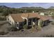 Expansive view of a desert home with red tile roof, desert landscaping, and views of the surrounding mountains at 9690 W Martin Rd, Casa Grande, AZ 85194