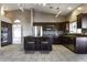 Kitchen features dark wood cabinets, stainless steel appliances, backsplash, island with bar seating, and tile flooring at 9690 W Martin Rd, Casa Grande, AZ 85194