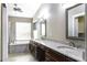 Bright main bathroom with dual sinks, soaking tub, separate shower, and wood look tile floor at 9690 W Martin Rd, Casa Grande, AZ 85194