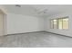 Minimalist bedroom featuring light gray tile flooring, a ceiling fan, and a large window at 1564 W Redwood Ln, Phoenix, AZ 85045