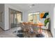 Bright dining area featuring a modern table set, sliding glass doors, large windows, and stylish decor at 1564 W Redwood Ln, Phoenix, AZ 85045