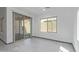 Bright living area with sliding glass doors, a large window, and neutral gray tile flooring at 1564 W Redwood Ln, Phoenix, AZ 85045