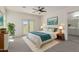 Bright main bedroom with a ceiling fan, balcony access, a painting, and an ensuite bathroom at 1564 W Redwood Ln, Phoenix, AZ 85045