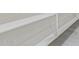 Close-up of a modern, white staircase featuring clean lines and sleek design against gray tile flooring at 1564 W Redwood Ln, Phoenix, AZ 85045