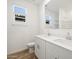 Bathroom featuring double sink vanity, toilet, and window. Wood-look flooring and white walls at 16084 W Prickly Pear Trl, Surprise, AZ 85387